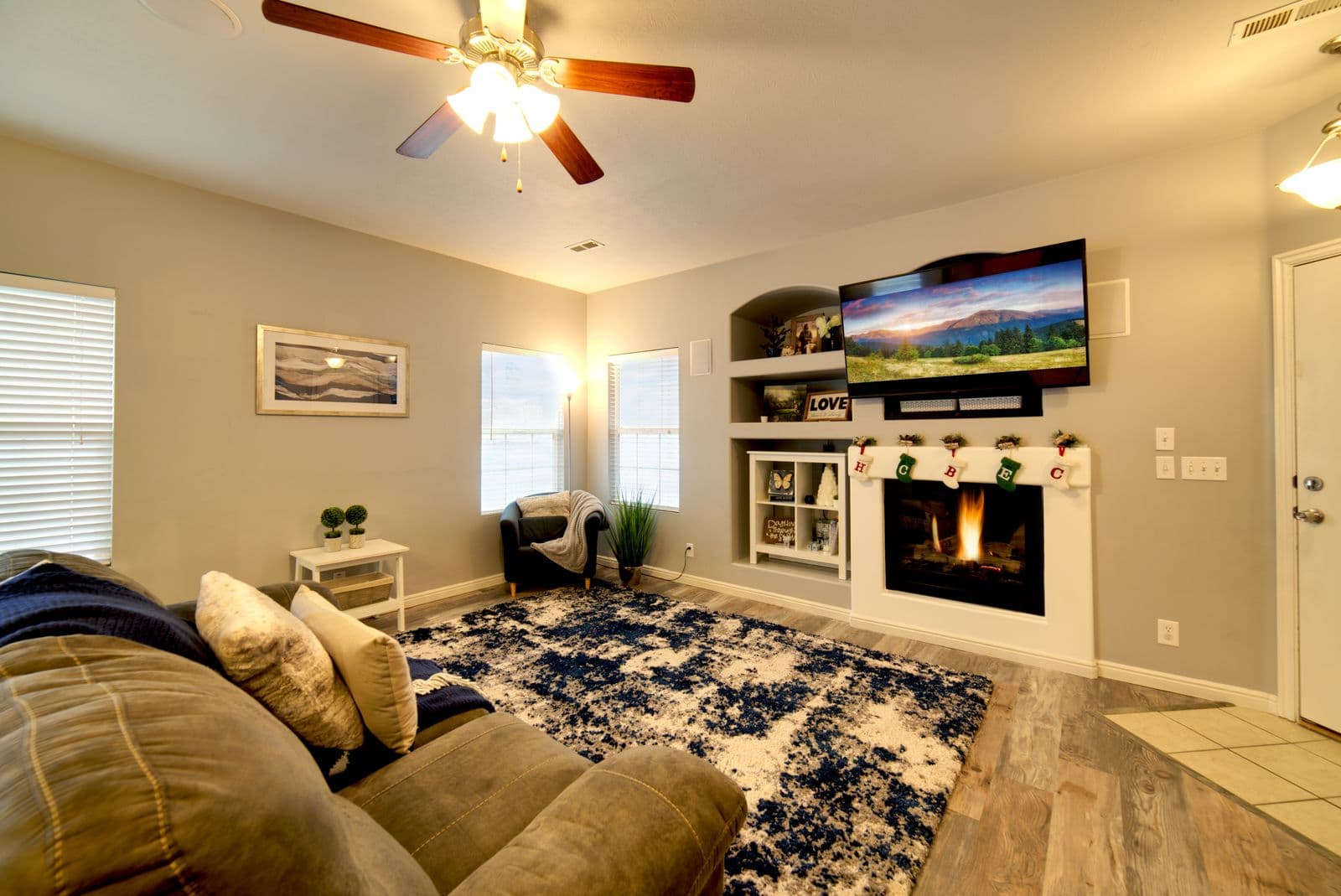 Flat-screen TV mounted flush on the wall above a lit fireplace